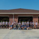 The riders outside of the fire station.