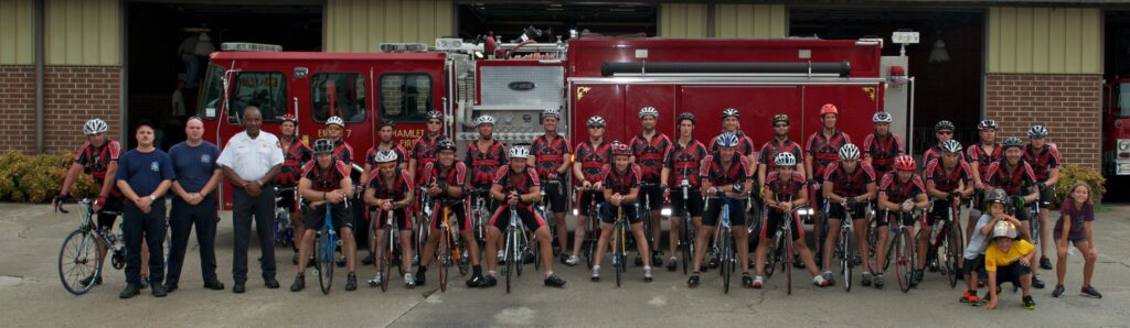 Riders in front of a fire truck.