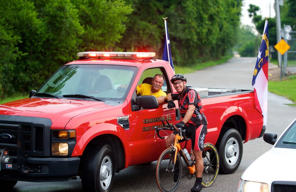 Man in fire truck and a rider pose together.