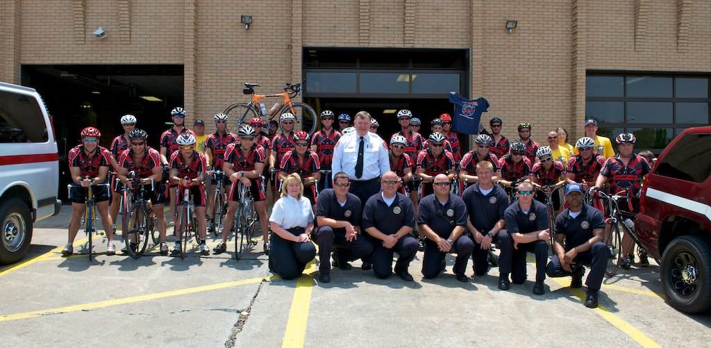 Firefighters and riders together outside the fire department.