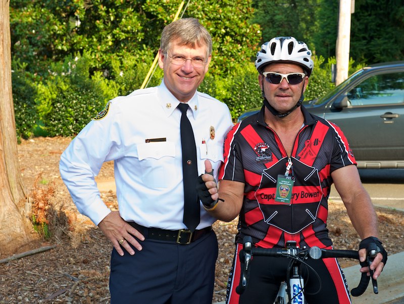 Fire chief and a rider pose together.